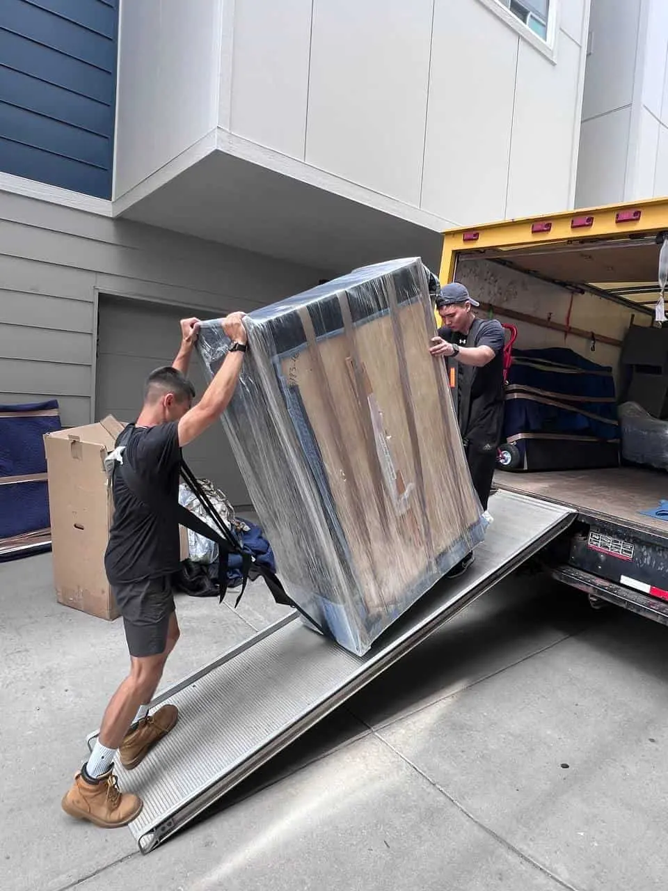 Mover lifting a wrapped item up the truck ramp